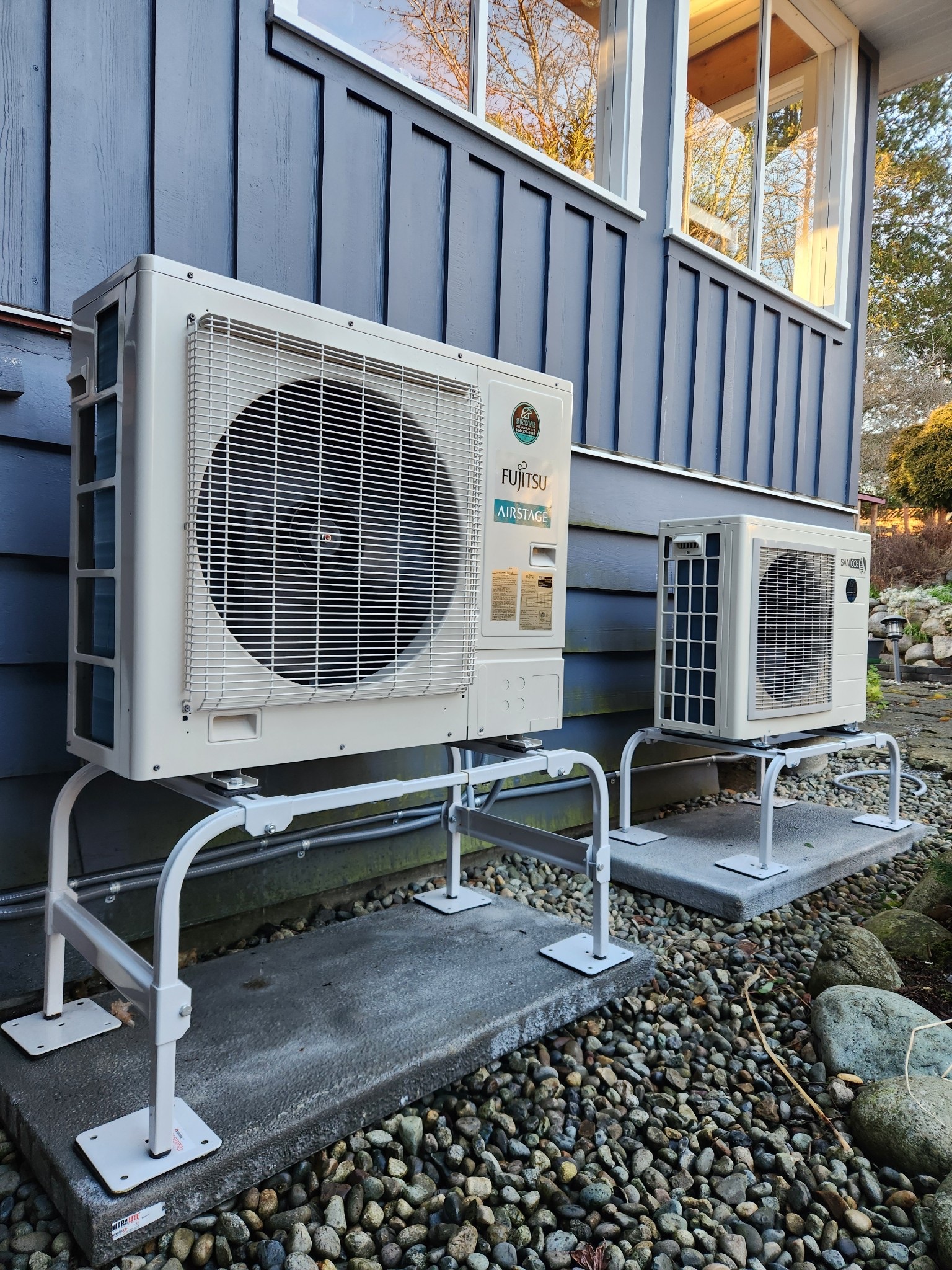 Fujitsu Airstage outdoor heat pump units installed on blue house