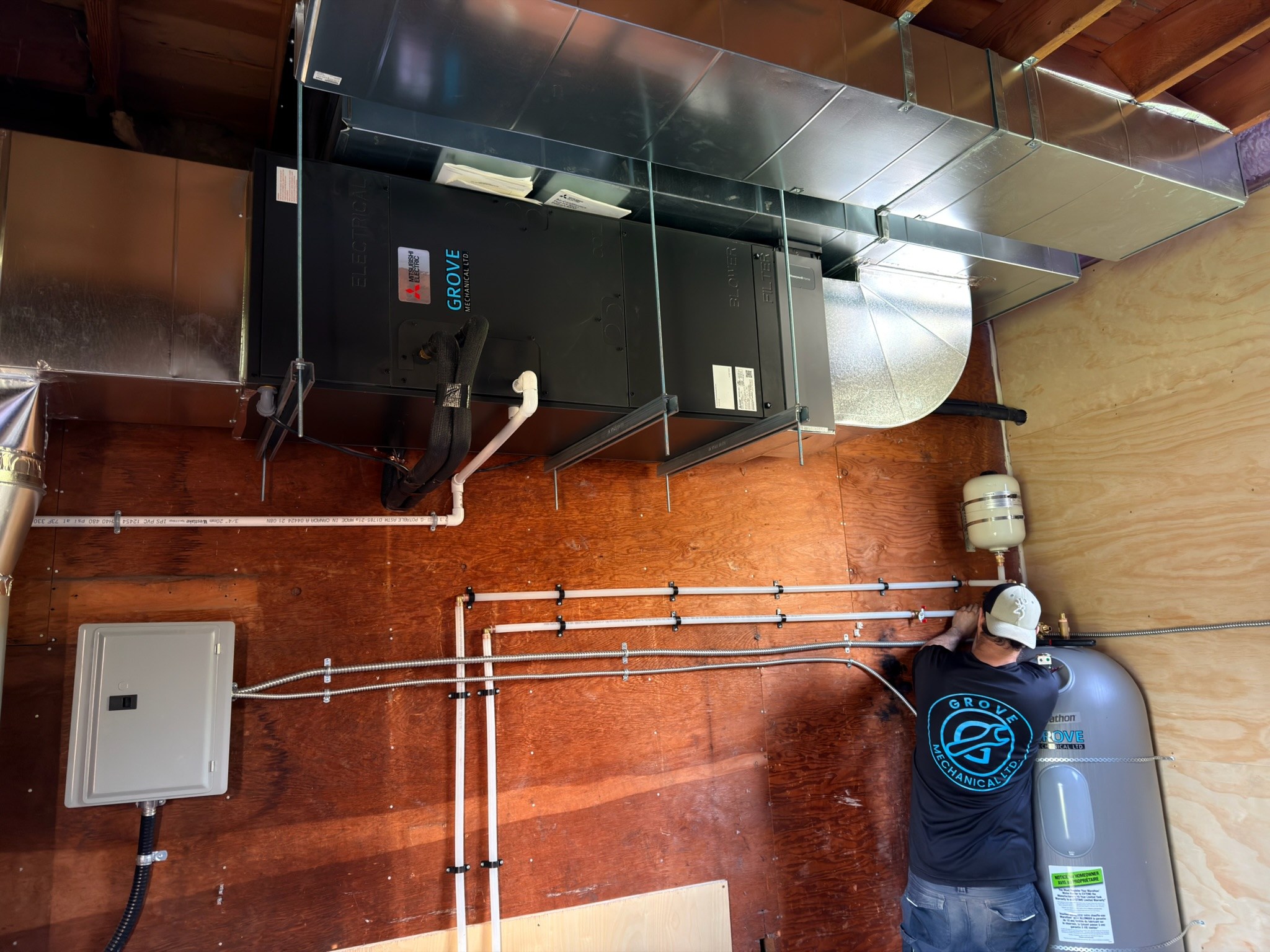Grove Mechanical technician installing plumbing and ductwork system
