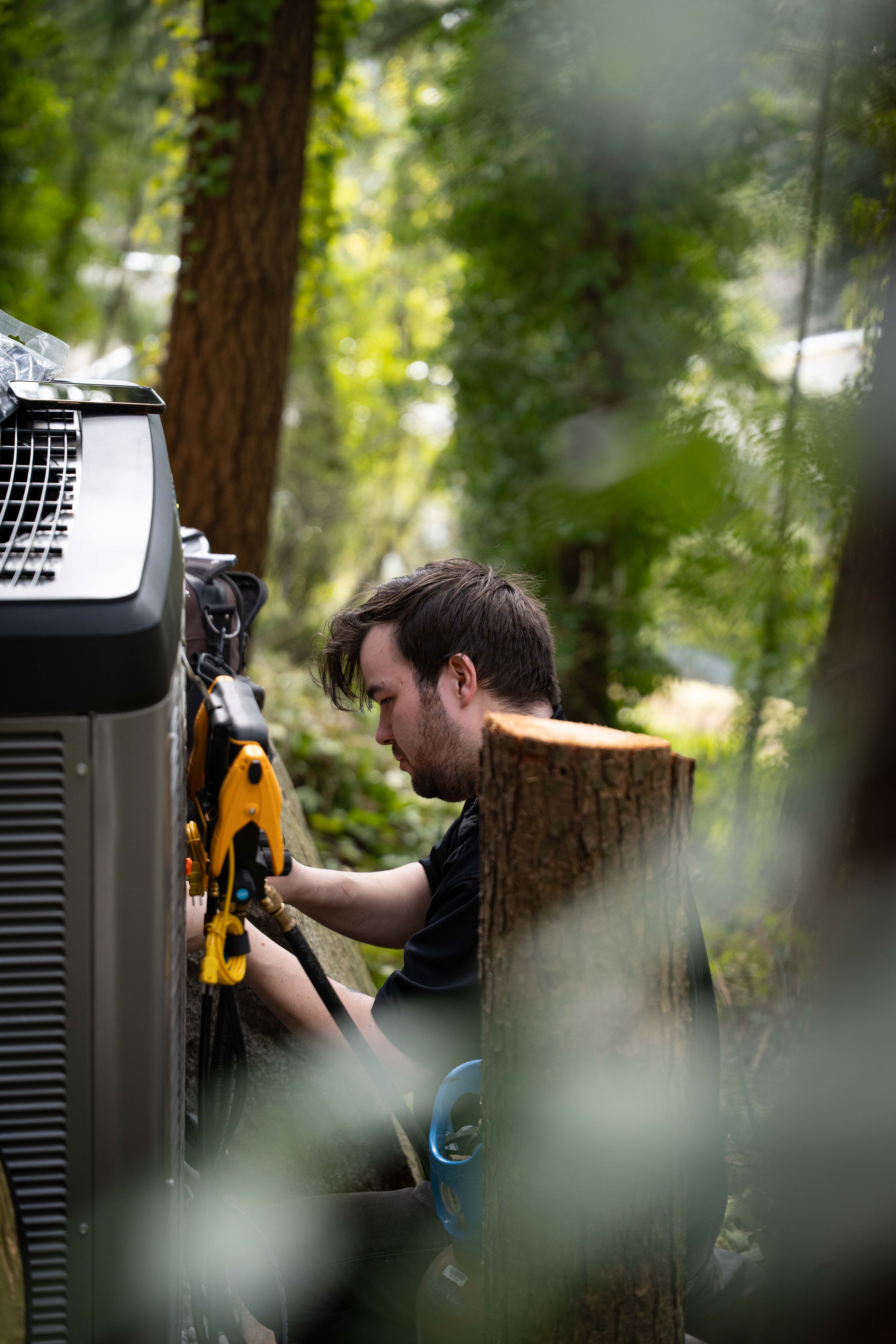 Grove Mechanical technician servicing outdoor heat pump unit
